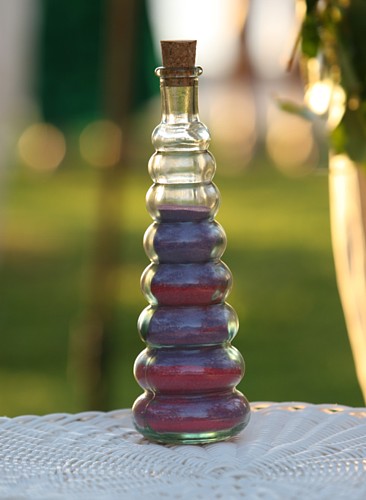 purple blue and dark pink sand in a glass